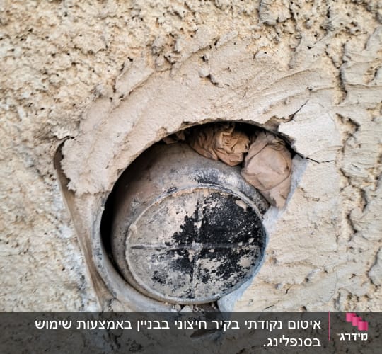 פתח עגול בקיר עם מכסה מתכת ישן